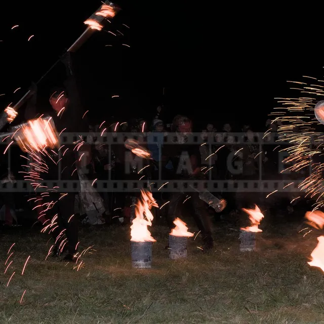 Fire sparkles fly as artist perform in front of the spectators at Beltane Fire Show at night