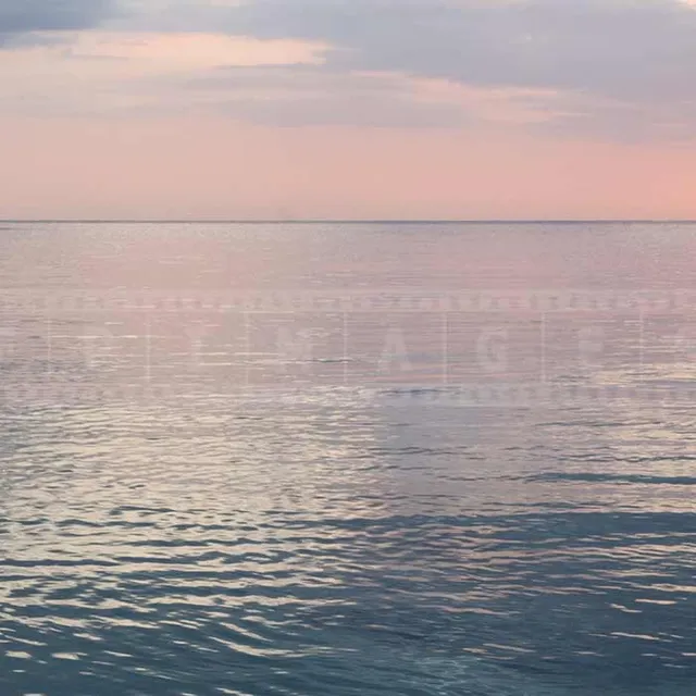 Couple watching gorgeous sunset over the Caribbean sea in Negril Jamaica