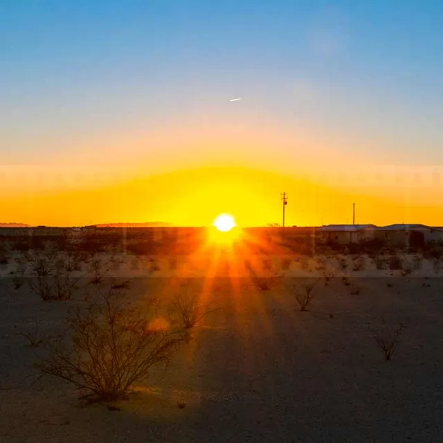 Sun rising above the horizon in the high desert of 29 Palms